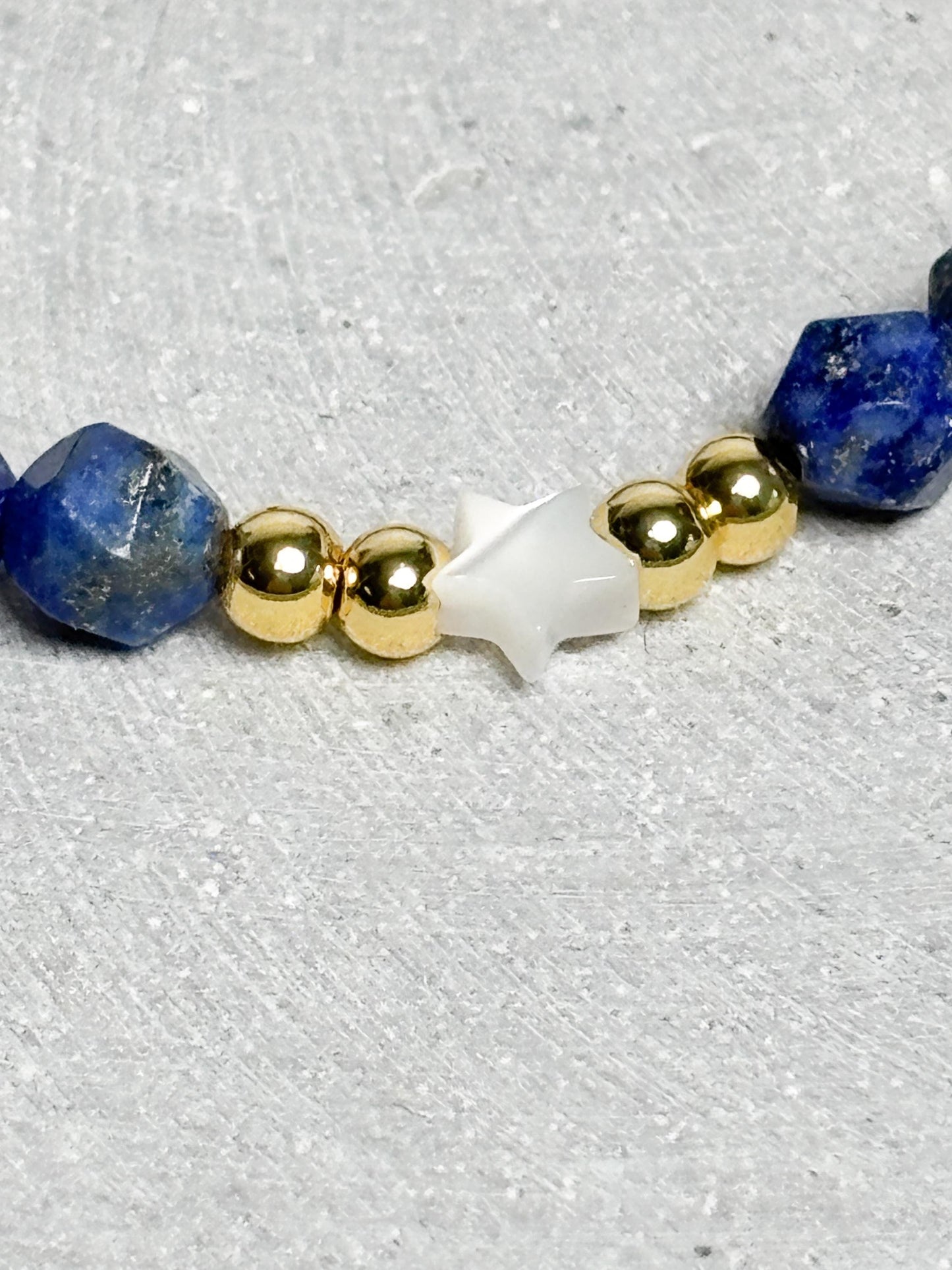 Elastisches Armband aus facettiertem Lapislazuli mit goldfarbenen Perlen und Muschelstern Edelsteinarmband Blau