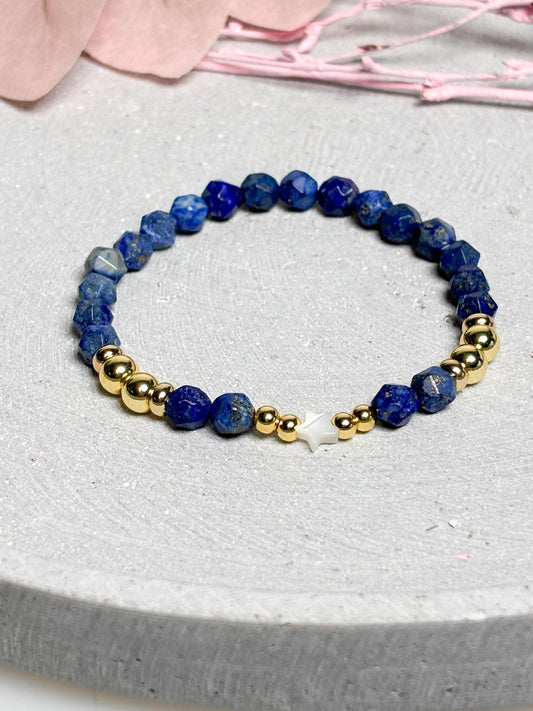Elastisches Armband aus facettiertem Lapislazuli mit goldfarbenen Perlen und Muschelstern  Edelsteinarmband Blau